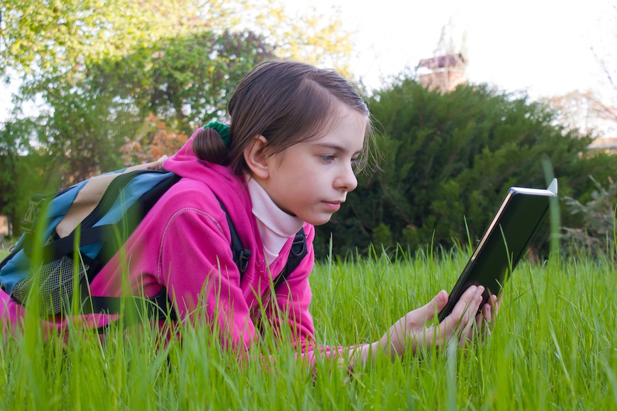 djevojčica čita u travi